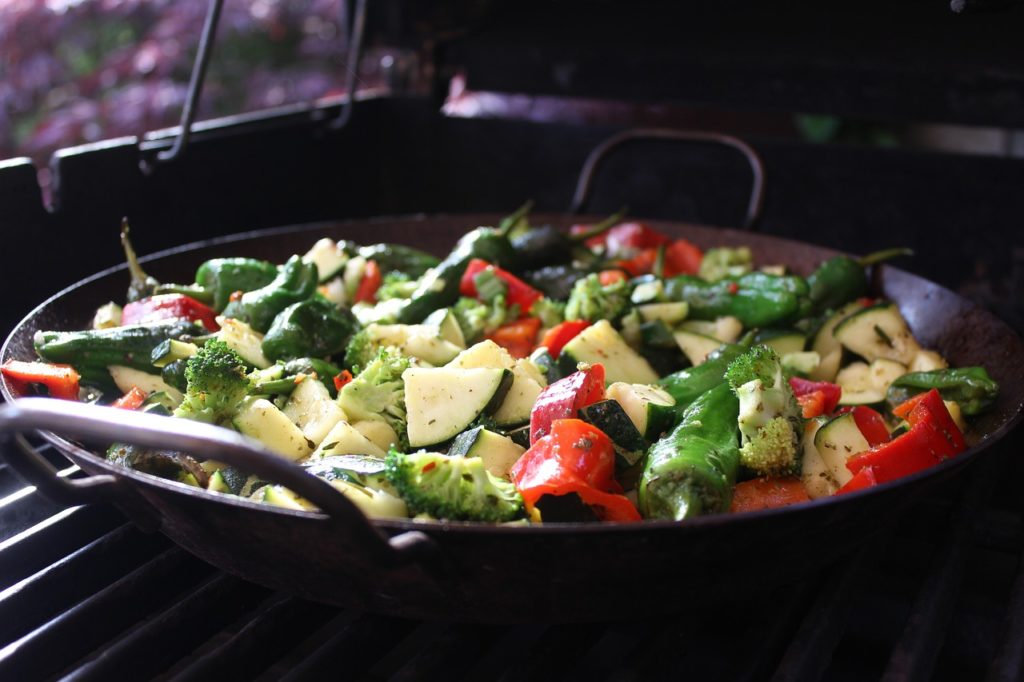 Grillpfanne mit Zucchini, Paprika, Brokkoli und grünen Schoten auf dem Grillrost