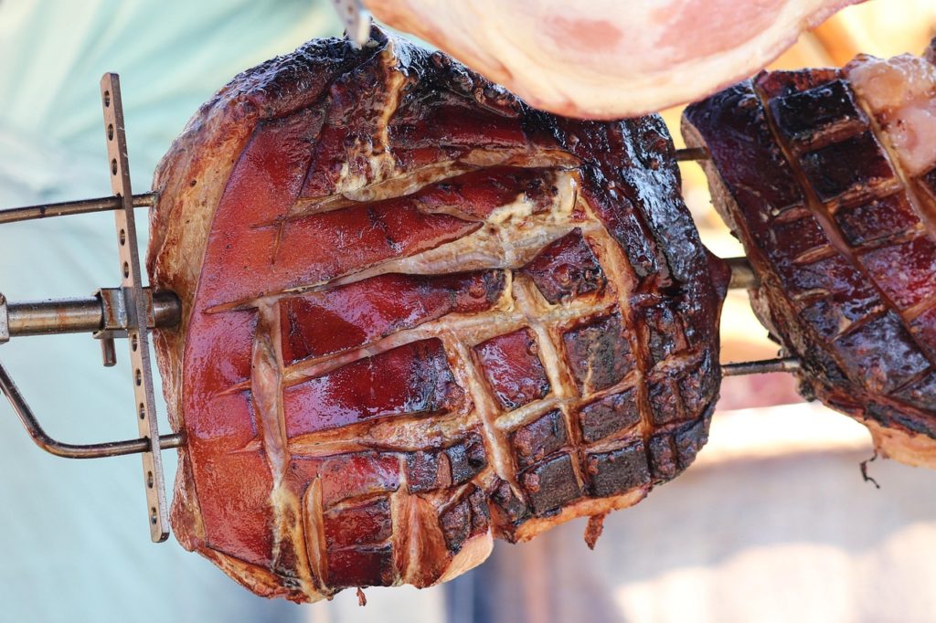 Schweinebraten mit rautenförmig eingeschnittener Schwarte am Drehspieß